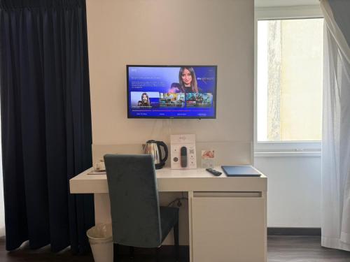 a room with a desk with a tv on the wall at Palazzo Cappuccini Art Relais in Naples