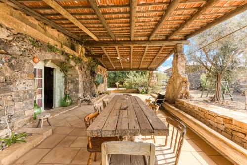 an outdoor patio with a wooden table and chairs at Guest House Fontanelle in Ugento