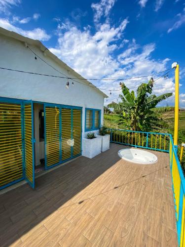 a wooden deck with a blue and yellow fence at La Trasnochadora - Duerme en una típica finca cafetera Colombiana in Pereira