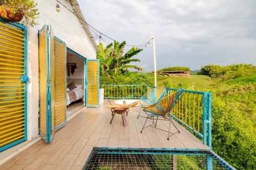a deck with a table and a chair on it at La Trasnochadora - Duerme en una típica finca cafetera Colombiana in Pereira