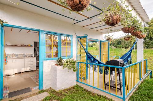 a house with a porch with a swing at La Trasnochadora - Duerme en una típica finca cafetera Colombiana in Pereira