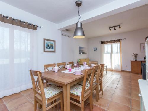 a dining room with a wooden table and chairs at Holiday Home in Zemunik Donji with Pool in Donji Zemunik