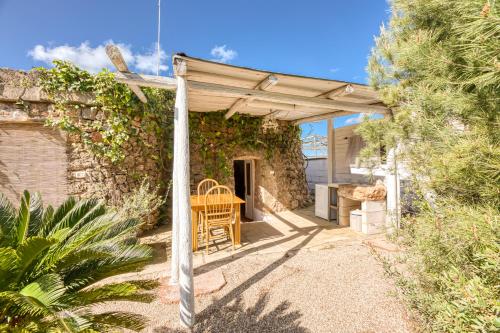 a wooden pergola with a table and chairs on a patio at Guest House Fontanelle in Ugento