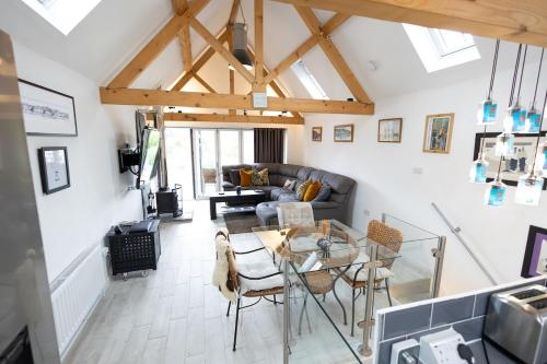 una sala de estar con una mesa y un sofá en Davids Dairy- a perfect getaway., en Kings Cliffe