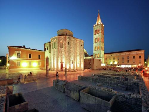 a large building with a clock tower at night at Holiday Home in Zemunik Donji with Pool in Donji Zemunik
