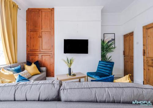 a living room with a couch and two blue chairs at 5BR House, Sleeps 10 guests - Free Parking - Great for Professionals & Contractors in Pontefract