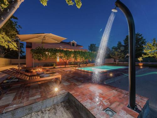a swimming pool with a fountain in a backyard at Holiday Home in Zemunik Donji with Pool in Donji Zemunik