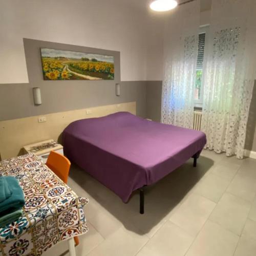 a bedroom with a purple bed and a table at CAMERE DI ARHET in Parma