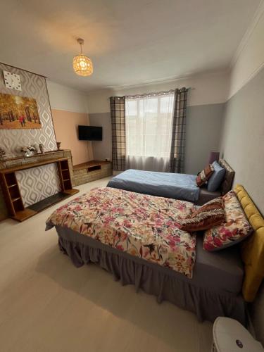 a bedroom with a large bed and a television at Private Room 2 Near Southmead Hospital in Bristol