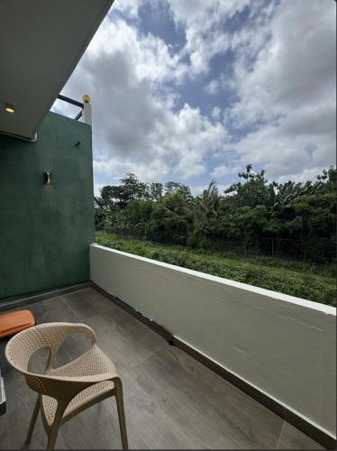 d'un balcon avec une chaise et une vue sur les arbres. dans l'établissement Chillnest, à Nugegoda