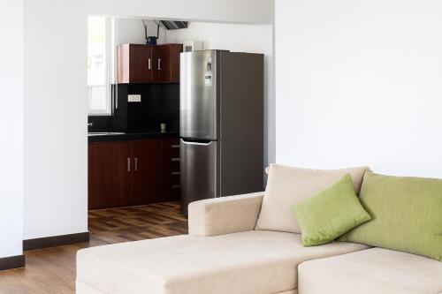 a living room with a couch and a refrigerator at Goalie Beachfront Resort in Hikkaduwa