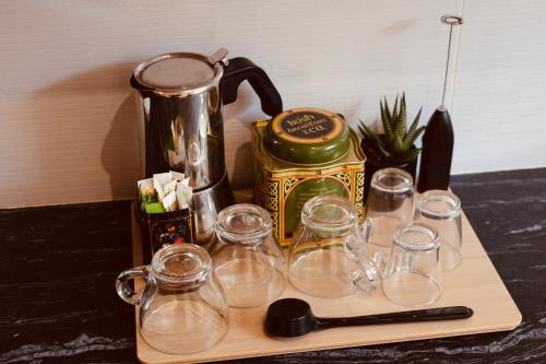 a group of glasses on a wooden tray with a coffee maker at Art Sounion, Seafront Elegance in Sounio