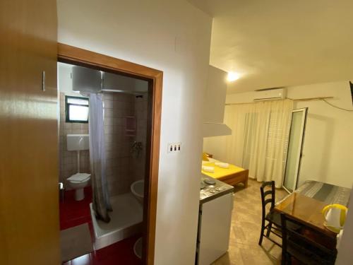 a bathroom with a shower and a kitchen with a table at Apartments San Giorgio in Sućuraj