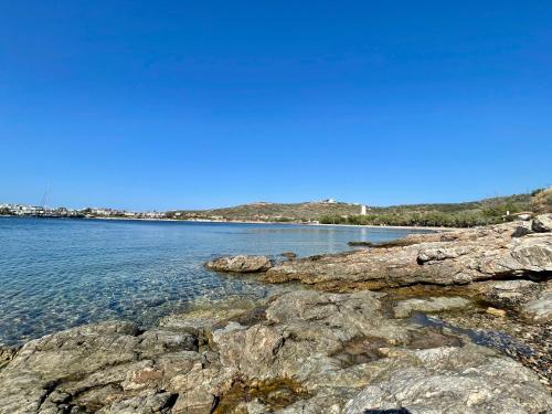 a large body of water with rocks in the foreground at Art Sounion, Seafront Elegance in Sounio