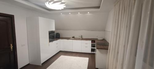 a white kitchen with a sink and a microwave at Emi's House in Sângeorgiu de Mureș