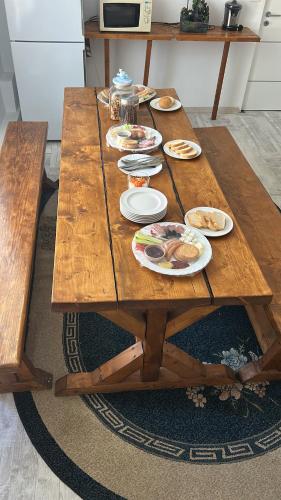 a wooden table with plates of food on it at Home COLOSSEUM GUEST HOUSE in Bucharest