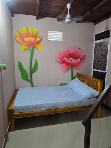 a bedroom with two flowers painted on the wall at YAS Beach Villa in Kattankudi