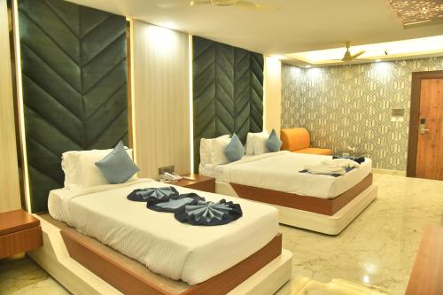a hotel room with two beds and a couch at City Square in Deoghar