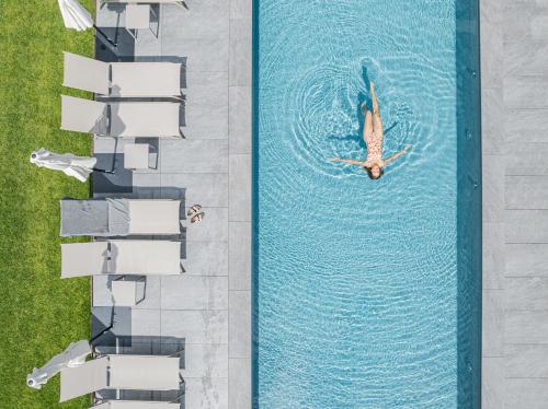 an overhead view of a person swimming in a pool at Alpenwellnesshotel St. Veit in Sesto
