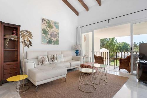 a living room with a white couch and tables at Beautiful Golfside Hideaway in Benahavís