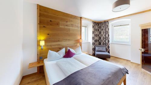 a bedroom with a large bed with a wooden headboard at Appartements Am Achensee in Pertisau