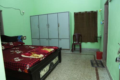 a bedroom with a bed and a chair at Sri Datta Ananda Nilayam in Pithāpuram