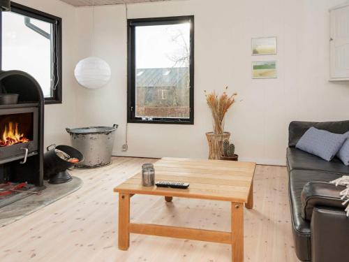 a living room with a coffee table and a fireplace at 5 person holiday home in Juelsminde-By Traum in Sønderby
