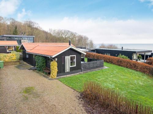 a small house with an orange roof in a yard at 5 person holiday home in Juelsminde-By Traum in Sønderby