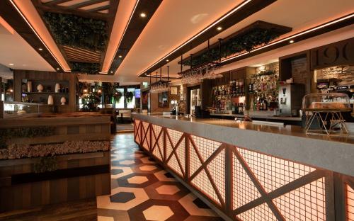 a bar with a long counter in a restaurant at Royal Hotel in Cumnock