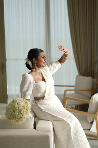 a woman in a white wedding dress sitting on a couch at Radisson Collection Resort Galle in Galle