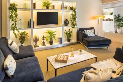 a living room with two couches and a tv at Melia Madrid Serrano in Madrid
