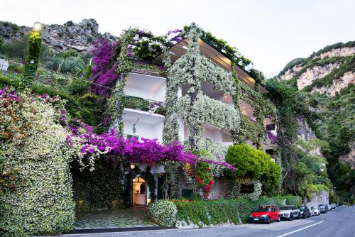 a building covered in flowers and plants on a street at Hotel Pellegrino in Praiano