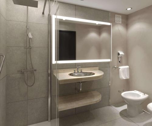 a bathroom with a shower and a sink and a toilet at NH Santiago del Estero in Santiago del Estero