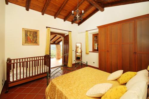 a bedroom with a bed and a crib at Villa Cosentino con Piscina privata & idromassaggio in SantʼAnna