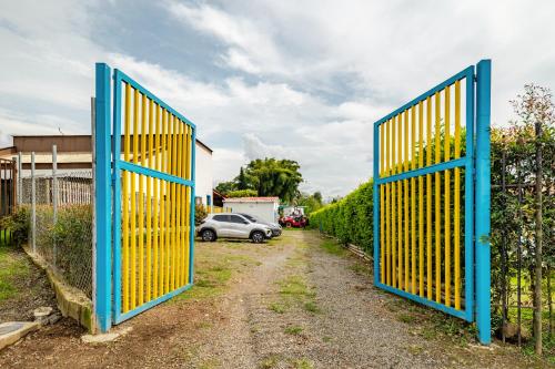 a pair of blue gates in front of a driveway at La Trasnochadora - Duerme en una típica finca cafetera Colombiana in Pereira