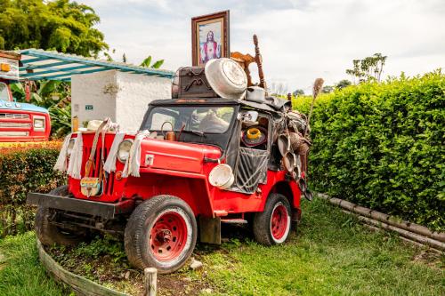 a red toy truck parked in the grass at La Trasnochadora - Duerme en una típica finca cafetera Colombiana in Pereira