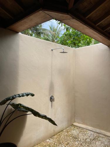 a shower in a wall with a plant next to it at Tumbuh Oasis in Letman
