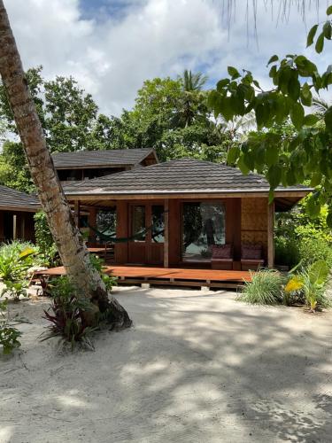 a house on the beach with a tree at Tumbuh Oasis in Letman
