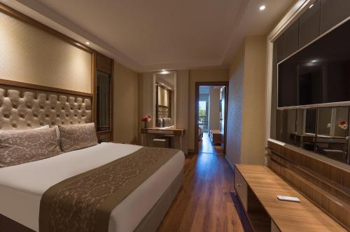 a hotel room with a bed and a television at Oz Hotels Sui in Alanya