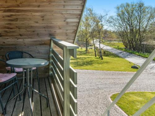 a wooden porch with a table and a fence at 4 person holiday home in Børkop in Børkop