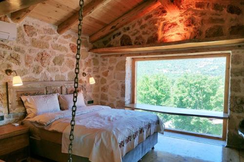 a bedroom with a swinging bed with a window at 3 Oda Kaş in Kas