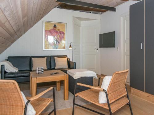 a living room with a couch and a table and chairs at 4 person holiday home in Børkop in Børkop