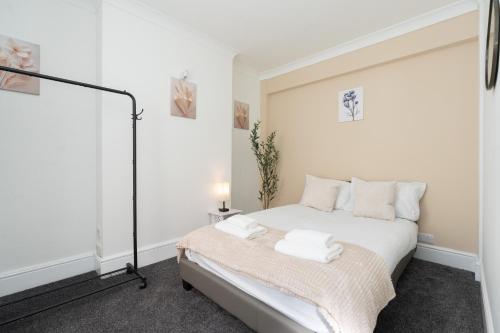 a white bedroom with a bed with white pillows at Open Mind Property - House with 6 Double Beds in Poole