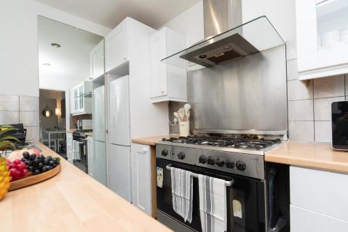 a kitchen with a stove and a counter at Open Mind Property - House with 6 Double Beds in Poole