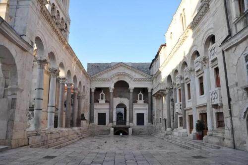 an empty courtyard of an old building with a cobblestone street at Apartments and Rooms Villa Erede in Split