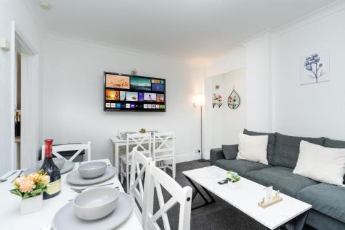 a living room with a couch and a table at Open Mind Property - House with 6 Double Beds in Poole