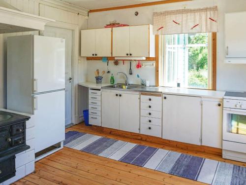 a kitchen with white cabinets and a white refrigerator at 5 person holiday home in KUNGSHAMN in Kungshamn