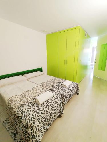 a bedroom with a bed and a green cabinet at Camping El Burgo Bungalows in Orellana la Vieja