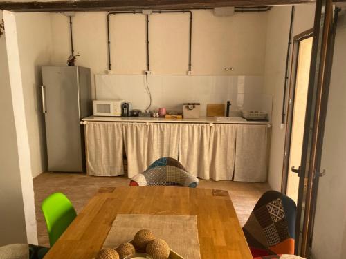 a room with a table and a kitchen with a refrigerator at La Terreta hotel casa rural in El Brosquil