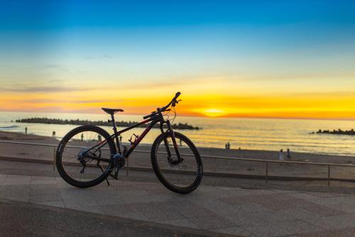 a bike parked on a sidewalk next to the beach at B&B Mikawa 6 - Loft Rooms in Hakusan